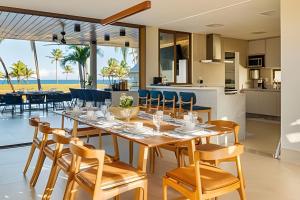 un comedor con mesa y sillas y el océano en Luxo a 50 m da praia, acesso ao Iberostar Resort en Praia do Forte