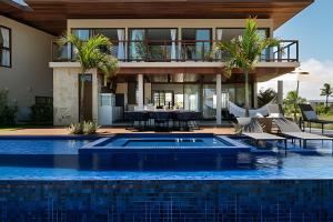 una casa con piscina frente a una casa en Luxo a 50 m da praia, acesso ao Iberostar Resort en Praia do Forte