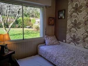 Un dormitorio pequeño con una cama y una ventana. en Ty Clafout Vannetaise parking wifi linge non inclus, en Saint-Nolff
