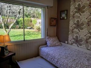 a small bedroom with a bed and a window at Ty Clafout Vannetaise in Saint-Nolff