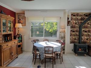 cocina con mesa, sillas y chimenea en Ty Clafout Vannetaise parking wifi linge non inclus, en Saint-Nolff