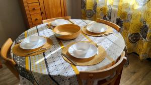 una mesa de comedor con sombreros y platos. en Les Tourterelles d'Avignon, en Aviñón