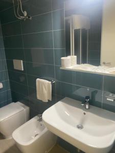 ein Badezimmer mit einem Waschbecken, einem WC und einem Spiegel in der Unterkunft luxury penthouse appartment in Castiglione della Pescaia