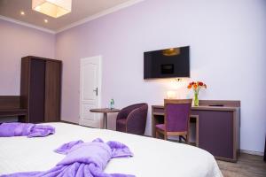 a hotel room with a purple blanket on a bed at Domus Apartments in Prague