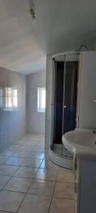 ein weißes Bad mit einer Dusche und einem Waschbecken in der Unterkunft Villa de 3 chambres avec terrasse et wifi a Saint Georges de Baroille in Saint-Georges-de-Baroille