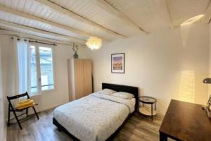 een slaapkamer met een bed en een tafel. bij Suites Rive Gauche - Proche Fontainebleau - Chez Christophe in Montereau-faut-Yonne