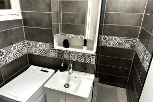 a small bathroom with a sink and a toilet at Suites Rive Gauche - Proche Fontainebleau - Chez Christophe in Montereau-Fault-Yonne