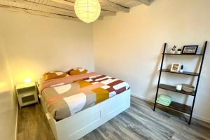 een slaapkamer met een bed en een boekenplank bij Suites Rive Gauche - Proche Fontainebleau - Chez Christophe in Montereau-faut-Yonne