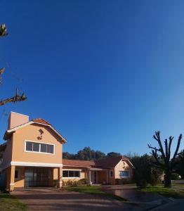 una casa en un barrio con un cielo azul en CASA BARRIO CERRADO EN LUJAN LA CONCEPCION en Luján
