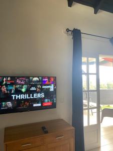 a flat screen tv on a wall in a living room at Blue dream Bungalow in Le Gosier