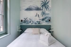a bedroom with a bed with a painting on the wall at HAMAC Suites / Suite St Antoine / 2 CH / Unique in Lyon
