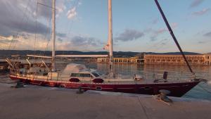 a sailboat is docked at a dock in the water at Bed & Breakfast & Sea with Captain in Pirovac