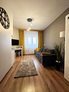 uma sala de estar com um sofá e uma mesa em Apartamenty w Kamienicy em Poddębice