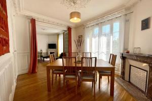 una sala da pranzo con tavolo, sedie e camino di 20min de Paris - Chez Daniel a Villemomble Altre 16 foto