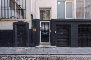 un bâtiment noir avec deux portes dans une rue dans l'établissement Splendid Flat Near Beatles Museum, à Liverpool