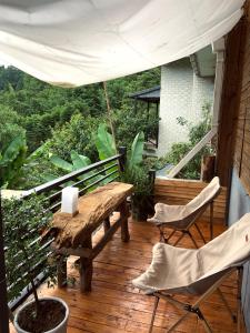 un patio con tavolo e sedie su un ponte di legno di Banshan Yard a Ya'an