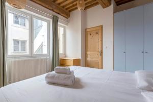 Una gran cama blanca con una pila de toallas. en Flat Fourvière view / Near Place des Terreaux en Lyon