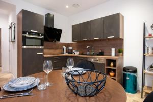 a kitchen with a wooden table with wine glasses on it at Apparts Gambetta in Libourne