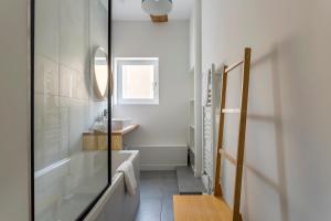 a bathroom with a tub and a sink and a mirror at Flat Fourvière view / Near Place des Terreaux in Lyon