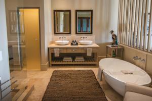 uma casa de banho com 2 lavatórios e uma banheira em Santé Wellness Retreat & Spa em Paarl