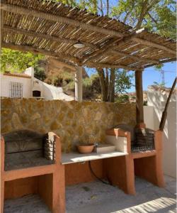 dos bancos sentados bajo una pérgola de madera en 3 bedrooms property with private pool at Cortes y Graena, en Graena