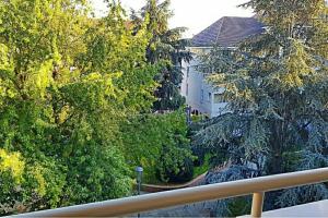 d'un balcon avec des arbres offrant une vue sur une maison. dans l'établissement Appartement d'une chambre avec terrasse et wifi a Poissy, à Poissy