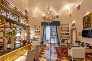 un bar con sedie bianche e un lampadario a braccio di Golden Tower Hotel & Spa a Firenze