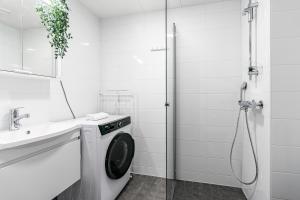 een badkamer met een wasmachine en een wastafel bij SPOT Apartments Hämeenlinna in Hämeenlinna