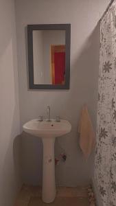 ein Badezimmer mit einem weißen Waschbecken und einem Spiegel in der Unterkunft Casa en Boca del Río in Las Tapias