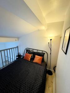 una camera con un letto con due cuscini arancioni di Confort & Charme Central - Gare Toulouse Matabiau - Centre ville a Tolosa