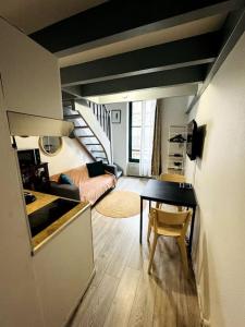 un soggiorno con scala e una camera con tavolo di Confort & Charme Central - Gare Toulouse Matabiau - Centre ville a Tolosa