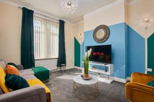 a living room with a couch and a tv at Large House in Newcastle City Centre - Sleeps 12 in Newcastle upon Tyne