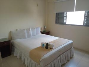 a bedroom with a large white bed with a window at La Siesta Hotel in Santa Cruz de la Sierra