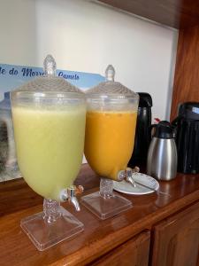 two glasses of drinks sitting on top of a counter at Pousada Brilho da Chapada New in Lençóis