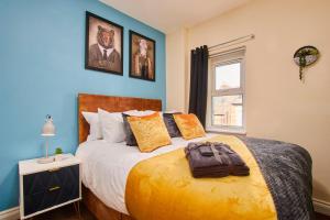 a bedroom with a large bed with blue walls at Sleek House - 5 Minutes From Newcastle City Centre in Newcastle upon Tyne