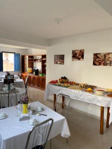 Pousada Brilho da Chapada New في لينكويس: غرفة طعام مع طاولتين مع مفارش أسرّة بيضاء