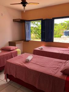 a room with three beds and two windows at Pousada Brilho da Chapada New in Lençóis