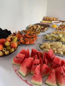 una mesa llena de diferentes tipos de fruta en los platos en Pousada Brilho da Chapada New en Lençóis