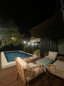 un patio con sillas y una piscina por la noche en Nana Field Cabin 3, en Ban Phra Fang 7 fotos más