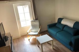 sala de estar con sofá azul y silla en Suites Rive Gauche - FONTAINEBLEAU - Chez Julien en Fontainebleau