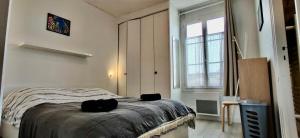 a bedroom with a bed and a large window at Suites Rive Gauche - DUPLEX Fontainebleau - Chez Guy in Fontainebleau