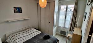 a small bedroom with a bed and a window at Suites Rive Gauche - DUPLEX Fontainebleau - Chez Guy in Fontainebleau