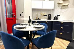 巴黎的住宿－Palais Royal - Chez Lucas，厨房配有带蓝色椅子的桌子和红色的门
