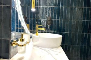 巴黎的住宿－Palais Royal - Chez Lucas，浴室设有白色水槽和金色水龙头