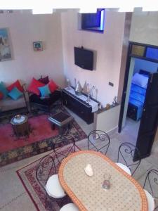 een woonkamer met een tafel en een bank bij DAR HIBa in Marrakesh