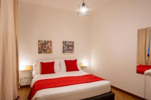 a bedroom with a large bed with red pillows at U Genova in Genova