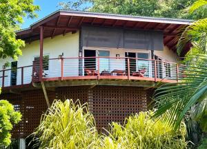 una casa con una terraza con sillas. en Casa Maya en West Bay