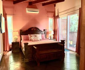 a bedroom with a large bed with pink walls at Casa Maya in West Bay