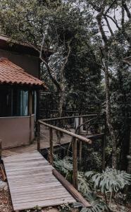 a wooden walkway leading to a house with trees at Casablanca Villas CB in Brumadinho