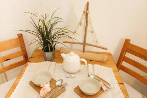 una mesa con dos platos y una tetera en ella en Villa Zur Alten Post, en Kühlungsborn